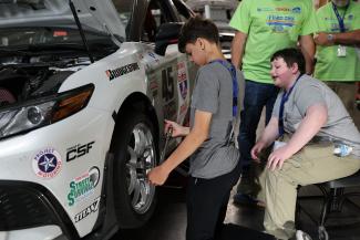 Campers working on car wheel