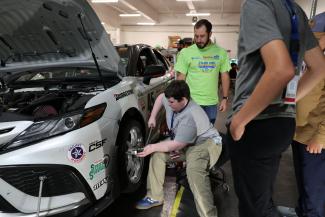 Camper working on car wheel