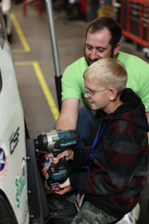 Camper working on car wheel